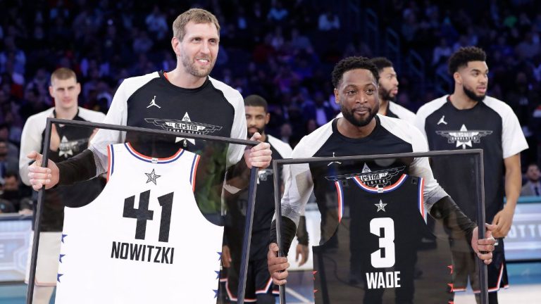 Dirk Nowitzki and Dwayne Wade are given jerseys during the second half of an NBA All-Star basketball game, Sunday, Feb. 17, 2019, in Charlotte, N.C. (Chuck Burton/AP Photo)