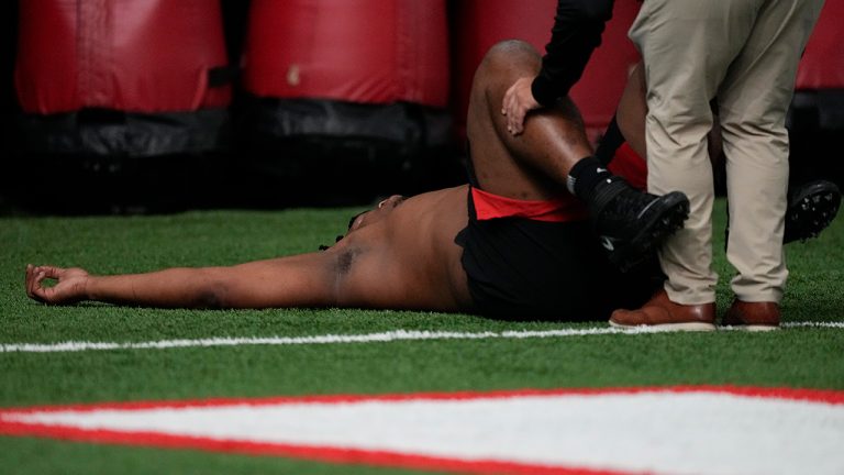 A trainer works with former Georgia defensive lineman Jalen Carter after he runs football drills during Georgia's Pro Day, Wednesday, March 15, 2023, in Athens, Ga (John Bazemore/AP)