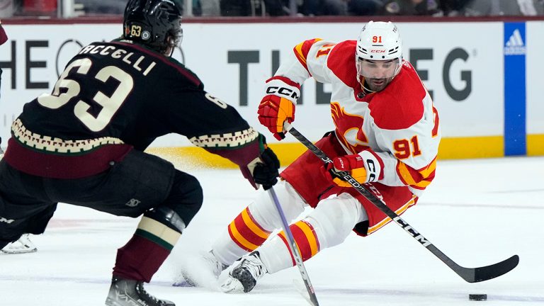 Calgary Flames center Nazem Kadri skates by Arizona Coyotes left wing Matias Maccelli (63) during the second period during an NHL hockey game Wednesday, Feb. 22, 2023, in Tempe, Ariz. (Rick Scuteri/AP)