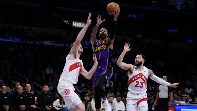 Los Angeles Lakers guard D'Angelo Russell (1) drives to the basket between Toronto Raptors center Jakob Poeltl, left, and guard Fred VanVleet during the first half of an NBA basketball game Friday, March 10, 2023, in Los Angeles. (Marcio Jose Sanchez/AP)