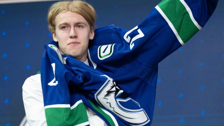 Vancouver Canucks 15th pick Jonathan Lekkerimaki puts on his jersey during the first round of the 2022 NHL Draft Thursday, July 7, 2022 in Montreal. (Ryan Remiorz/CP)