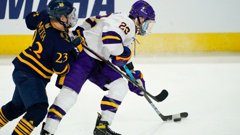 Minnesota State defenceman Jake Livingstone, right, fights for control of the puck with Quinnipiac defenceman Zach Metsa. (David Zalubowski/AP)