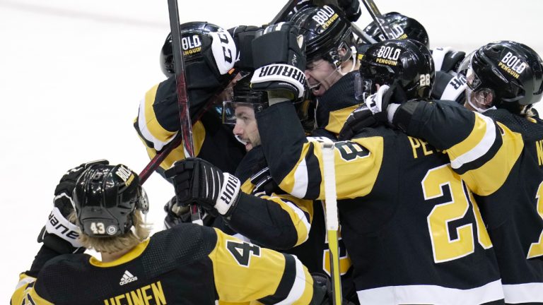 Pittsburgh Penguins' Kris Letang, center, is swarmed by teammates after getting the winning goal in the overtime period of an NHL hockey game against the New York Rangers in Pittsburgh, Sunday, March 12, 2023. (Gene J. Puskar/AP)