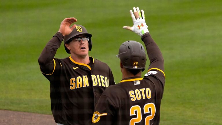 San Diego Padres' Brandon Dixon, left, celebrates with Juan Soto (22) after scoring on a double by Tim Lopes during the fourth inning of a spring training baseball game against the Texas Rangers Wednesday, March 1, 2023, in Peoria, Ariz. (Charlie Riedel/AP Photo)