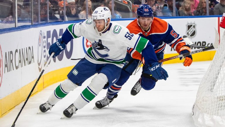 Vancouver Canucks' Guillaume Brisebois (55) is chased by Edmonton Oilers' Dylan Holloway (55) during second period preseason action in Edmonton on Monday, October 3, 2022. (Jason Franson/CP)