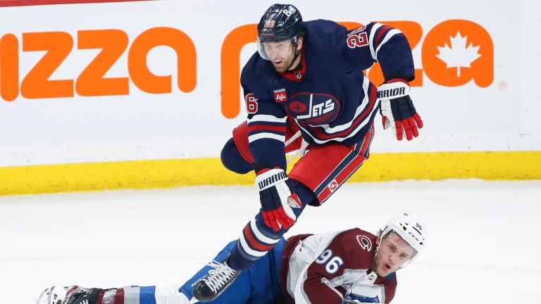 Winnipeg Jets' Blake Wheeler (26) leaps over Colorado Avalanche's Mikko Rantanen (96) as he goes down during second period NHL action in Winnipeg, Friday, February 24, 2023. (John Woods/CP)