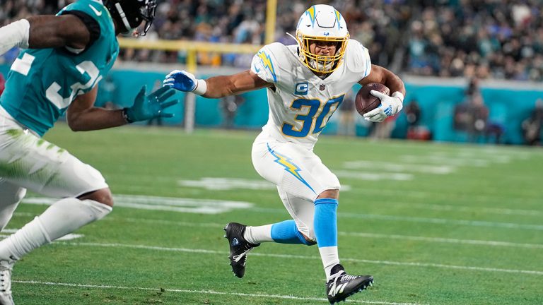 Los Angeles Chargers running back Austin Ekeler (30) heads to the end zone for a touchdown against Jacksonville Jaguars cornerback Tyson Campbell (32) during the first half of an NFL wild-card football game, Saturday, Jan. 14, 2023, in Jacksonville, Fla. (Chris Carlson/AP)