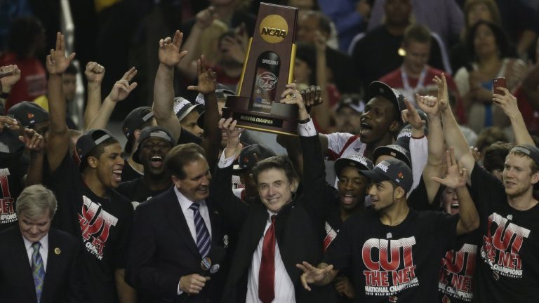 FILE - Louisville players and head coach Rick Pitino celebrate after defeating Michigan 82-76 in the final game at the NCAA Final Four tournament college basketball championship game Monday, April 8, 2013, in Atlanta. (Chris O'Meara/AP)