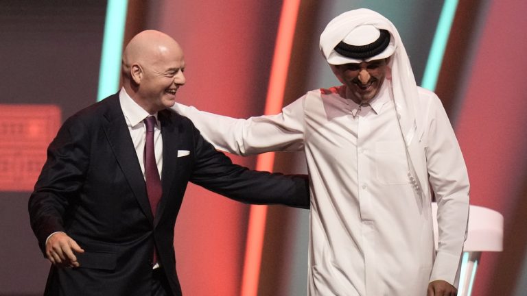 FIFA President Gianni Infantino, left, and Emir of Qatar Sheikh Tamim bin Hamad Al Thani leave the stage before the 2022 soccer World Cup draw at the Doha Exhibition and Convention Center in Doha, Qatar, on April 1, 2022. (Hassan Ammar/AP)