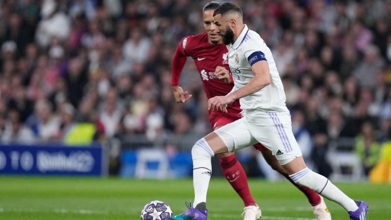 Liverpool's Virgil van Dijk, left, challenges Real Madrid's Karim Benzema during the Champions League, round of 16, second leg soccer match between Real Madrid and Liverpool at the Santiago Bernabeu stadium in Madrid, Spain, Wednesday, March 15, 2023. (Bernat Armangue/AP)