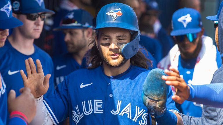 Toronto Blue Jays' Bo Bichette greeted by team mates in the dugout after scoring against the Philadelphia Phillies in the first inning of their spring training game in Dunedin, Fla., Sunday, March 5, 2023. (Fred Thornhill/CP)