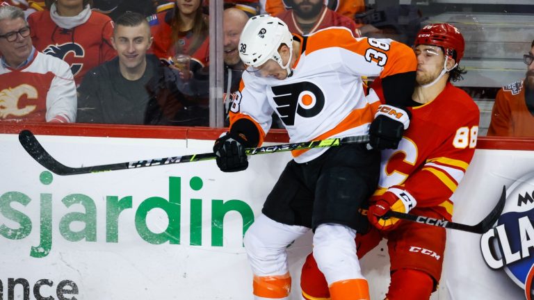 Philadelphia Flyers forward Patrick Brown, left, checks Calgary Flames forward Andrew Mangiapane during first period NHL hockey action in Calgary, Alta., Monday, Feb. 20, 2023. (Jeff McIntosh/THE CANADIAN PRESS)