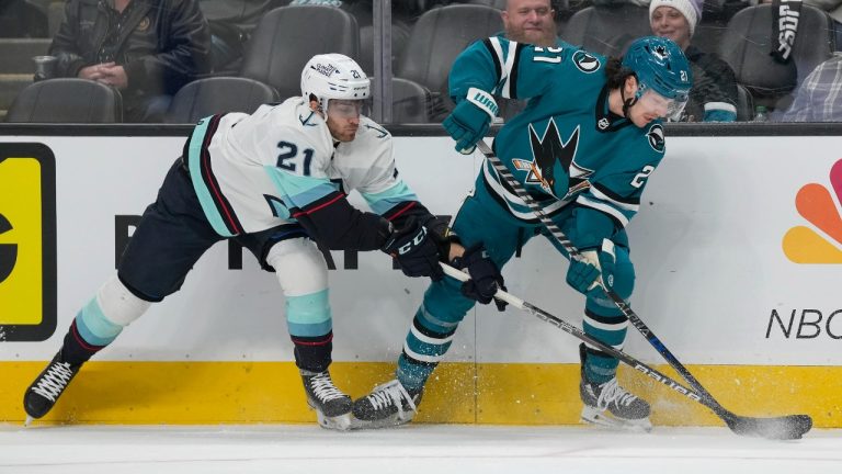 San Jose Sharks center Michael Eyssimont, right, reaches for the puck next to Seattle Kraken center Alex Wennberg during the first period of an NHL hockey game in San Jose, Calif., Monday, Feb. 20, 2023. (Jeff Chiu/AP)