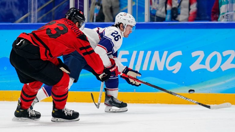 Canada's Tyler Wotherspoon (23) closely defends United States' Sean Farrell (26) during a preliminary round men's hockey game at the 2022 Winter Olympics, Saturday, Feb. 12, 2022, in Beijing. (Matt Slocum/AP)