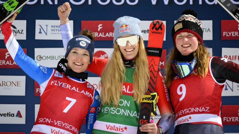 Winner Fanny Smith of Switzerland, second placed Jade Grillet Aubert of France, left, and third placed Tiana Gairns of Canada celebrate on the podium during the women's FIS Ski Cross World Cup, SX, in Veysonnaz, Switzerland, Sunday, March 12, 2023. (Laurent Gillieron/Keystone via AP)