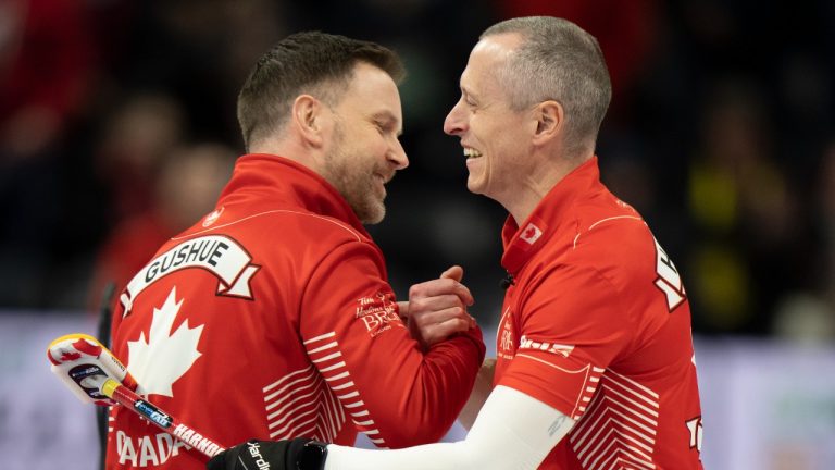 Canada skip Brad Gushue and second EJ Harnden celebrate after defeating Manitoba in the 1/2 playoff game at the 2023 Tim Hortons Brier in London, Ont. on Saturday March 11, 2023. (Frank Gunn/CP)