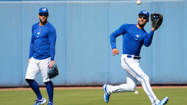 Toronto Blue Jays outfielders Kevin Kiermaier, right, catches a ball next to George Springer during baseball spring training in Dunedin, Fla., Monday, Feb. 20, 2023. (Nathan Denette/CP)