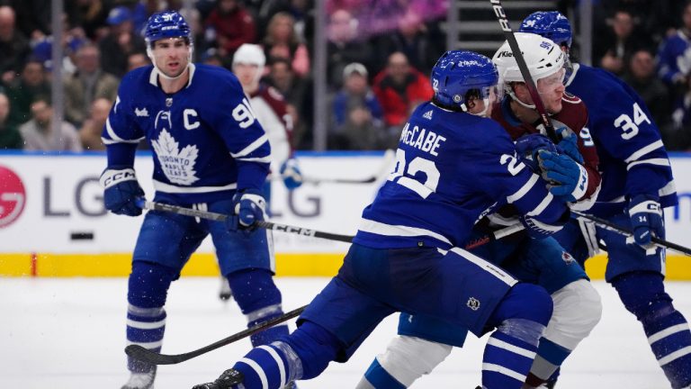 Toronto Maple Leafs' Jake McCabe (22) checks Colorado Avalanche's Mikko Rantanen (96) into Maple Leafs' Auston Matthews (34) as John Tavares (91) looks on during third period NHL action in Toronto on Wednesday, March 15, 2023. (Frank Gunn/CP)