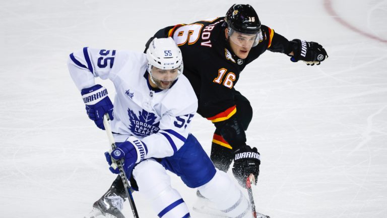 Toronto Maple Leafs defenceman Mark Giordano, left, is checked by Calgary Flames defenceman Nikita Zadorov during first period NHL hockey action in Calgary, Thursday, March 2, 2023. (Jeff McIntosh/CP)