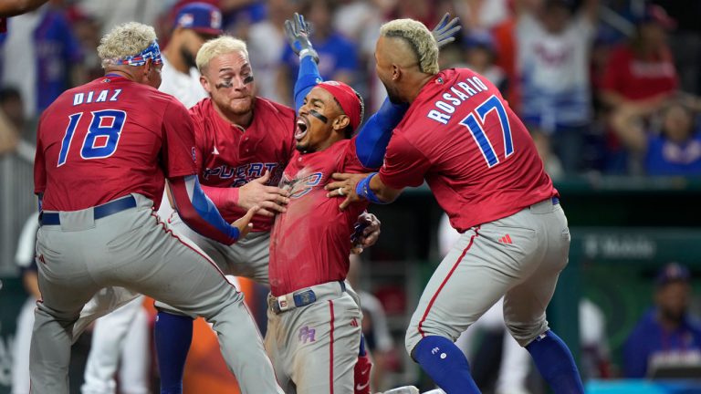 Puerto Rico's Francisco Lindor second from right, celebrates with teammates after he scored on a fielding error by Dominican Republic center fielder Julio Rodriguez during the fifth inning of a World Baseball Classic game. (Wilfredo Lee/AP)