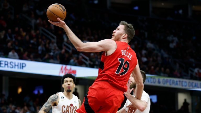 Toronto Raptors center Jakob Poeltl (19) shoots against Cleveland Cavaliers forward Dean Wade (32) and forward Danny Green (14) during the second half of an NBA basketball game, Sunday, Feb. 26, 2023, in Cleveland. (Ron Schwane/AP)