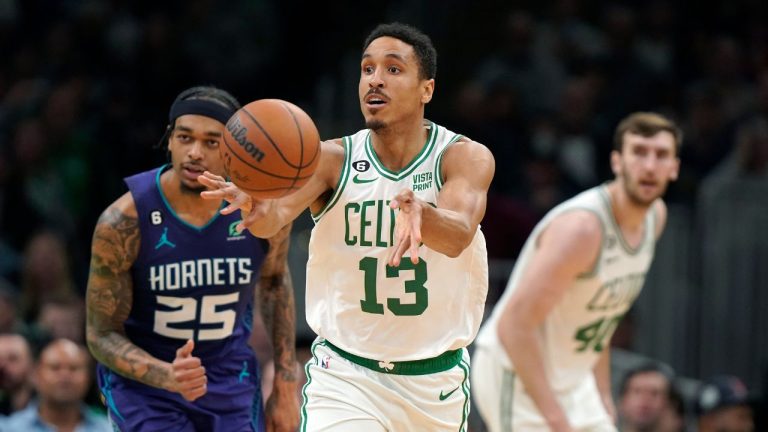 Boston Celtics guard Malcolm Brogdon passes the ball in front of Charlotte Hornets forward P.J. Washington  during the first half of an NBA basketball game, Monday, Nov. 28, 2022, in Boston. (Steven Senne/AP Photo)