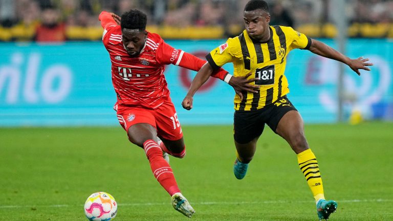 Bayern Munich's Alphonso Davies (left) vies for the ball with Borussia Dortmund's Youssoufa Moukoko during the German Bundesliga soccer match in Dortmund, Germany, Saturday, Oct. 8, 2022. (Martin Meissner/AP)