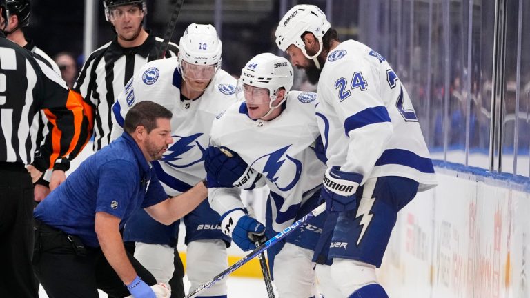 A Tampa Bay Lightning trainer and Corey Perry (10) and Zach Bogosian (24) help Tanner Jeannot (84) get up after Jeannot was hurt during the second period of the team's NHL hockey game against the New York Islanders on Thursday, April 6, 2023, in Elmont, N.Y. (Frank Franklin II/AP) 