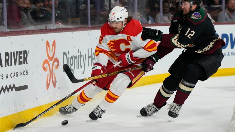 Calgary Flames defenseman Chris Tanev (8) shields the puck from Arizona Coyotes left wing Nick Ritchie during the first period during an NHL hockey game Wednesday, Feb. 22, 2023, in Tempe, Ariz. (Rick Scuteri/AP)