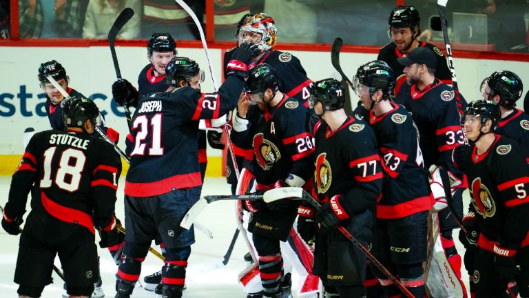 Ottawa Senators right wing Claude Giroux (28) is swarmed by teammates as they help him celebrates his 1,000th career point after assisting a goal against the Carolina Hurricanes in first period NHL action in Ottawa on Monday, April 10, 2023. (CP)