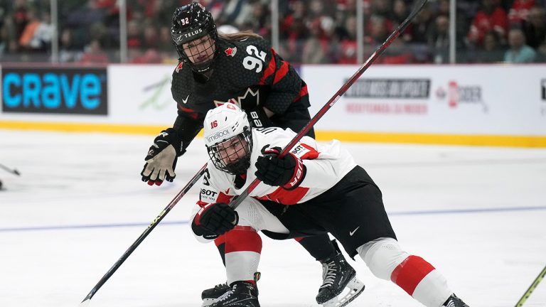 Canada forward Danielle Serdachny (92) battles for the puck against Switzerland defender Nicole Vallario (16) during second period IIHF Women's World Hockey Championship hockey action in Brampton, Ont., on Wednesday, April 5, 2023. (Nathan Denette/CP)