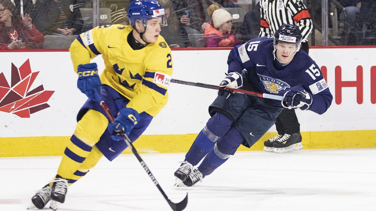 Sweden's Elias Pettersson looks up ice to make a pass as Finland's Lenni Hameenaho gives chase during second period IIHF World Junior Hockey Championship quarterfinal hockey action in Moncton, N.B., on Monday, Jan. 2, 2023. (CP)