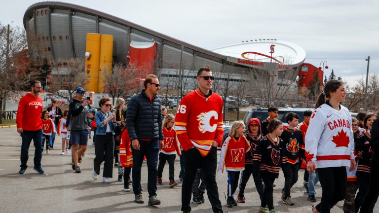 Calgary Flames' Michael Stone, centre, and Canadian women's team member Rebecca Johnston arrive with others for an announcement on plans for an events centre to replace the aging Saddledome, in Calgary, Alta., Tuesday, April 25, 2023. (Jeff McIntosh/CP)