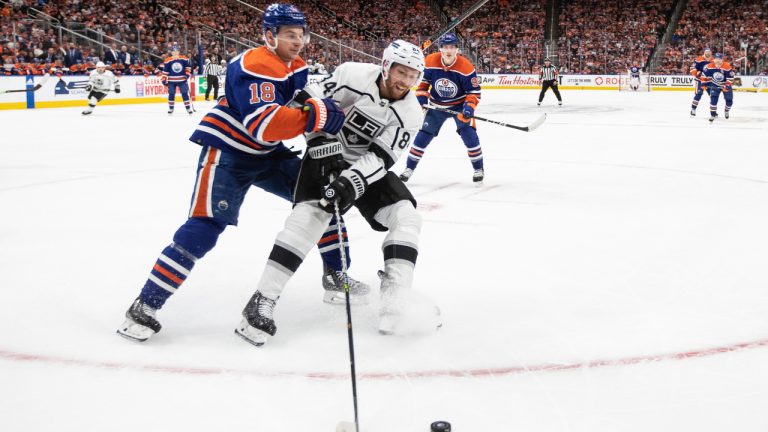 Los Angeles Kings' Vladislav Gavrikov (84) and Edmonton Oilers' Zach Hyman (18) battle for the puck during second period NHL Stanley Cup first round playoff action in Edmonton on Monday April 17, 2023. (Jason Franson/CP)