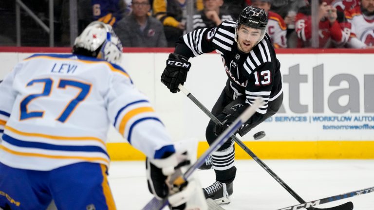 New Jersey Devils center Nico Hischier (13) takes a shot on Buffalo Sabres goaltender Devon Levi (27) during the second period of an NHL hockey game, Tuesday, April 11, 2023, in Newark, N.J. (John Minchillo/AP)