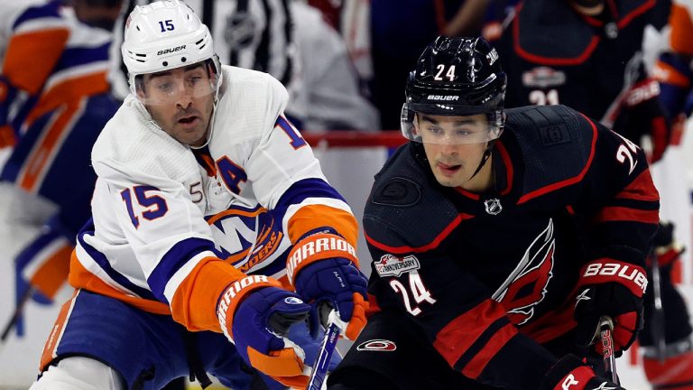 Carolina Hurricanes' Seth Jarvis (24) protects the puck from New York Islanders' Cal Clutterbuck (15) during the first period of an NHL hockey game in Raleigh, N.C., Sunday, April 2, 2023. (AP Photo/Karl B DeBlaker)