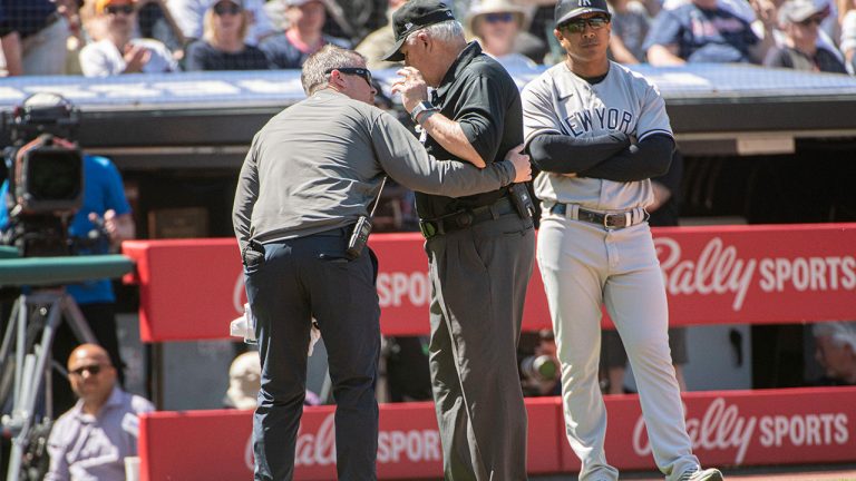 Umpire Larry Vanover is attended to by a Cleveland Guardians trainer after being hit by a throw from the outfield during the fifth inning of a baseball game in Cleveland, Wednesday April 12, 2023. (Phil Long/AP)