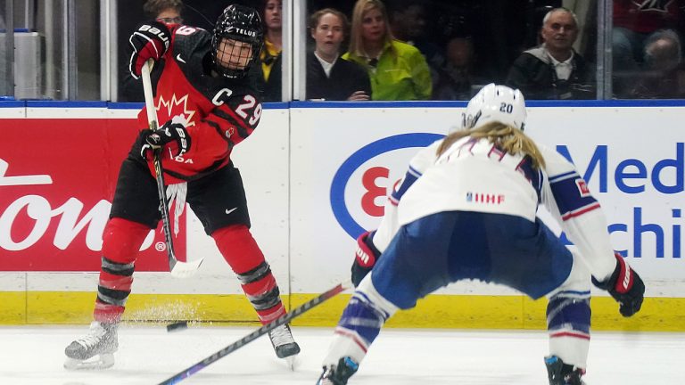 Canada's Marie-Philip Poulin (29) passes as United States' Hannah Brandt (20) defends during third period Rivalry Series hockey action in Kelowna, B.C., Tuesday, Nov. 15, 2022. (Jesse Johnston/CP)