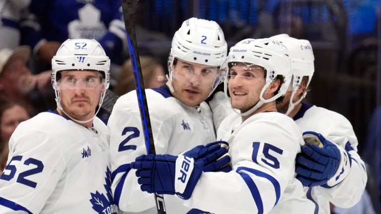 Toronto Maple Leafs defenceman Luke Schenn (2) celebrates his goal against the Tampa Bay Lightning with centre Noel Acciari (52) and centre Alexander Kerfoot (15) during the first period of an NHL hockey game Tuesday, April 11, 2023, in Tampa, Fla. (Chris O'Meara/AP)