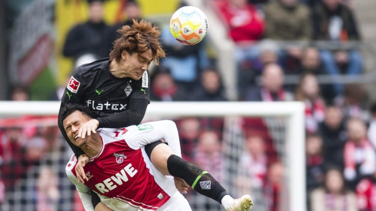 Cologne's Davie Selke, bottom, and Gladbach's Ko Itakura fight for the ball during the German Bundesliga soccer match between Cologne and Borussia Moenchengladbach, at the RehinEnergioStadion in Cologne, Germany, Sunday, April 3, 2023. (Marius Becker/dpa via AP)