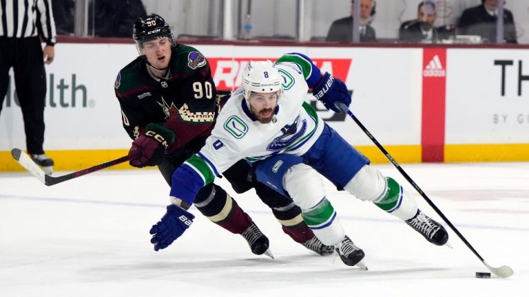 Vancouver Canucks right wing Conor Garland shields the puck from Arizona Coyotes defenceman J.J. Moser (90) in overtime during an NHL hockey game Thursday, April 13, 2023, in Tempe, Ariz. (Rick Scuteri/AP)