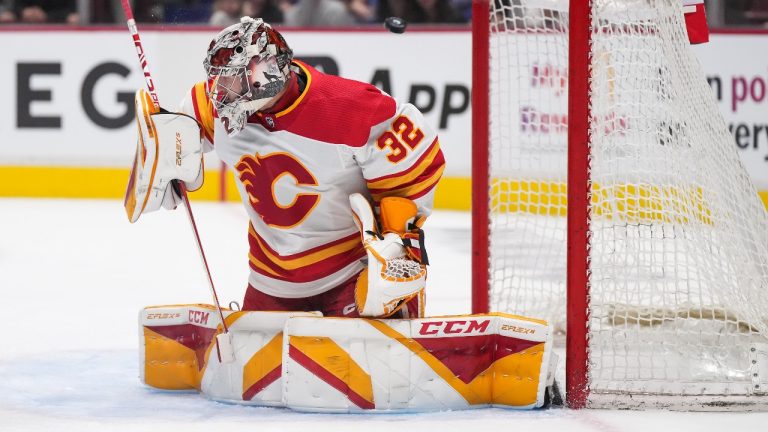 Calgary Flames goalie Dustin Wolf makes a blocker save against the Vancouver Canucks during the second period of a pre-season NHL hockey game in Vancouver, B.C., Sunday, Sept. 25, 2022. (Darryl Dyck/CP)