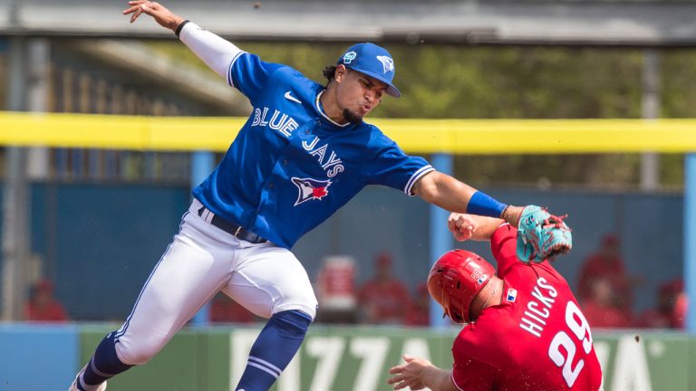 Philadelphia Phillies catcher John Hicks is safe stealing second base under the tag of Toronto Blue Jays second baseman Santiago Espinal during the second inning of their spring training baseball game. (Fred Thornhill/The Canadian Press)