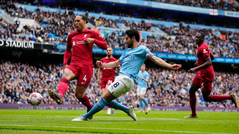 Manchester City's Ilkay Gundogan, center, scores his his side's third goal, challenged by Liverpool's Virgil van Dijk during the English Premier League soccer match between Manchester City and Liverpool at Etihad stadium in Manchester, England,Saturday, April 1, 2023. (Jon Super/AP)