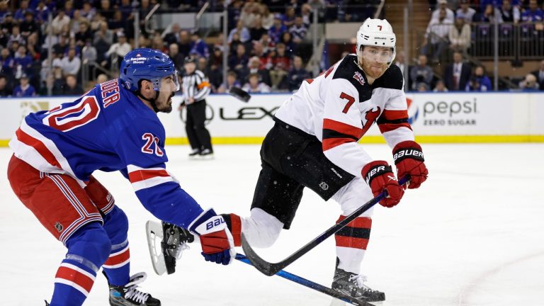 New Jersey Devils defenceman Dougie Hamilton clears the puck past New York Rangers left wing Chris Kreider during the first period of Game 3 of a Stanley Cup first-round playoff series Saturday, April 22, 2023, in New York. (Adam Hunger/AP)