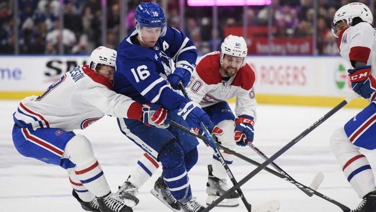 Toronto Maple Leafs forward Mitchell Marner (16) breaks past Montreal Canadiens defenceman Mike Matheson (8), forward Alex Belzile (60) and forward Christian Dvorak (28) during second period NHL hockey action, in Toronto on Saturday, Feb. 18, 2023. THE CANADIAN PRESS/Christopher Katsarov