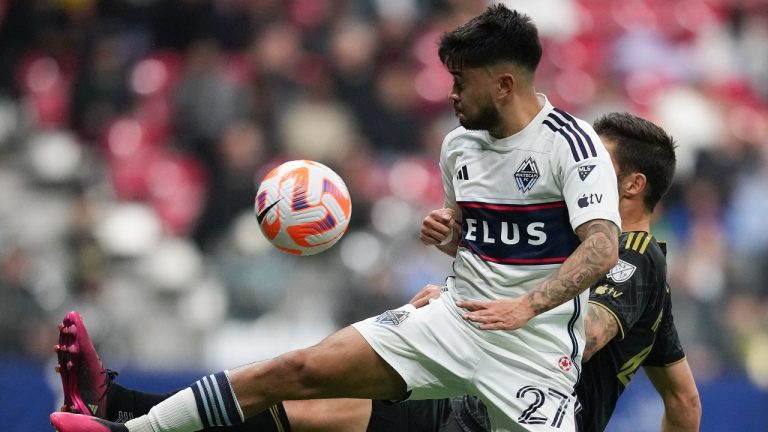 Vancouver Whitecaps' Ryan Raposo, front, and Los Angeles FC's Ryan Hollingshead vie for the ball during the first half of a Concacaf Champions League quarterfinal soccer match, in Vancouver, on Wednesday, April 5, 2023. (Darryl Dyck/CP)