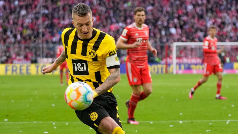 Dortmund's Marco Reus, left, vies for the ball with Bayern's Matthijs de Ligt during the German Bundesliga soccer match between FC Bayern Munich and Borussia Dortmund at the Allianz Arena stadium in Munich, Germany, Saturday April 1, 2023. (Matthias Schrader/AP)