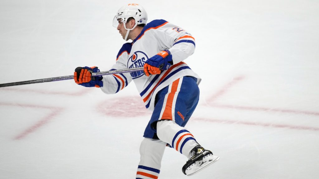 Edmonton Oilers' William Lagesson (84) checks Winnipeg Jets