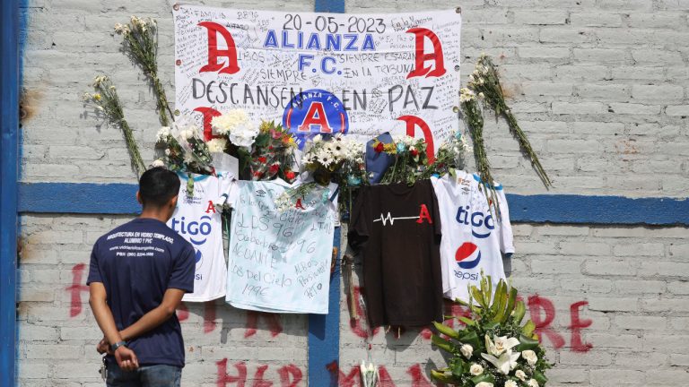 A fan of Alianza FC looks at a memorial set up as a tribute to the soccer fans killed in the recent Cuzcatlan stadium stampede, outside the stadium in San Salvador, El Salvador, Monday, May 22, 2023. The tragedy occurred when stampeding fans pushed through one of the access gates during a quarterfinal Salvadoran league soccer match between Alianza and FAS. (Salvador Melendez/AP)